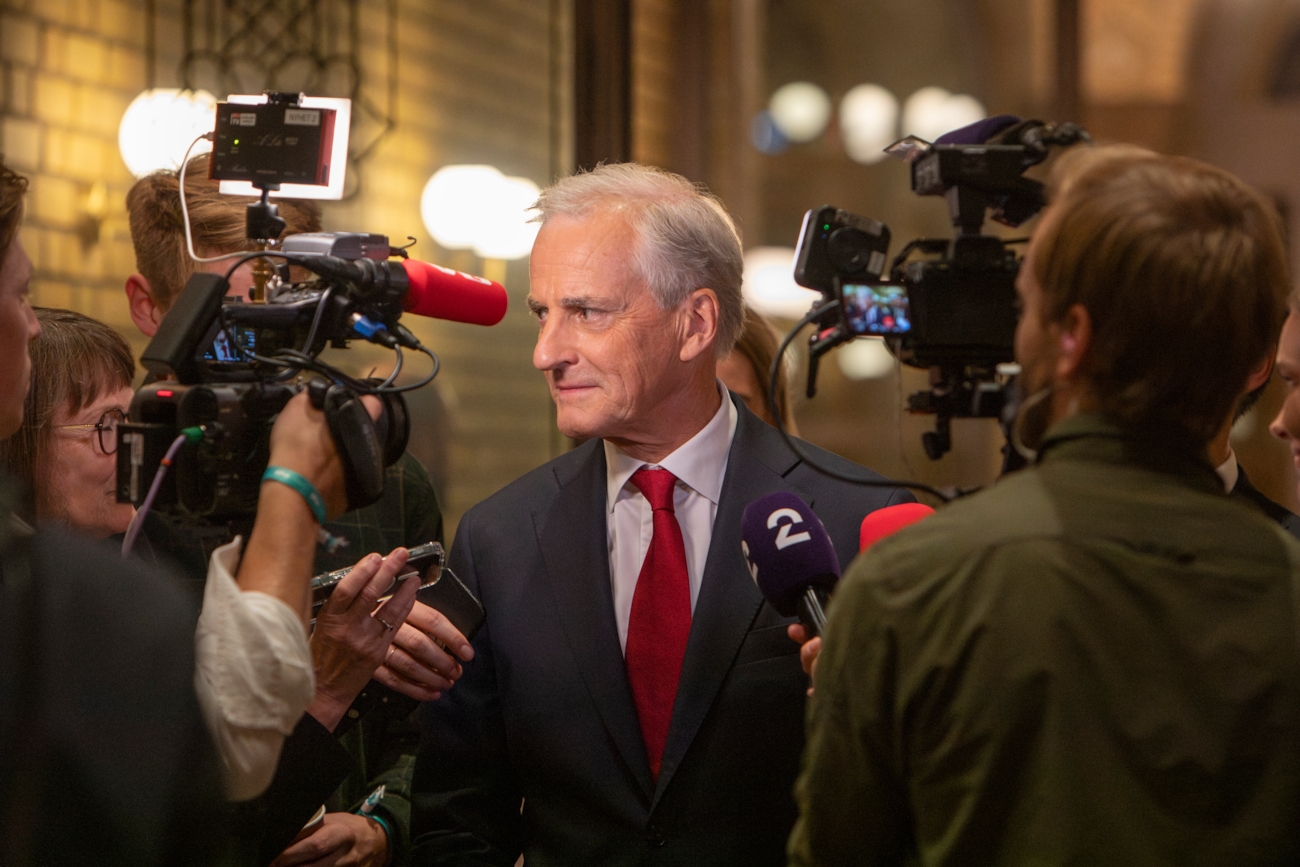 En mann blir intervjuet med flere kamera og mikrofoner rundt seg.