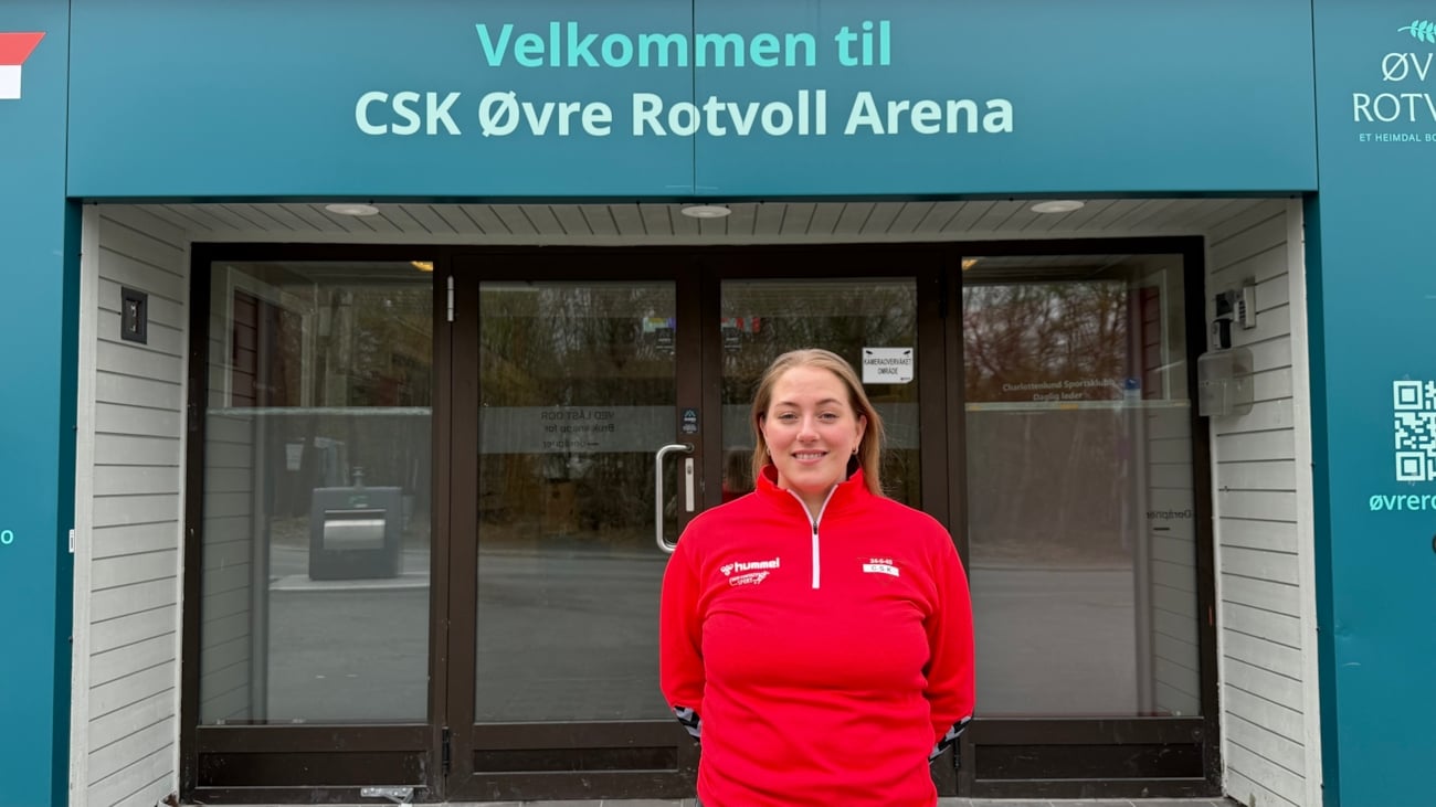 En dame står foran en dør.