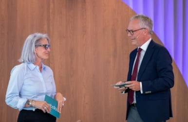 En dame og en mann snakker sammen på en scene.