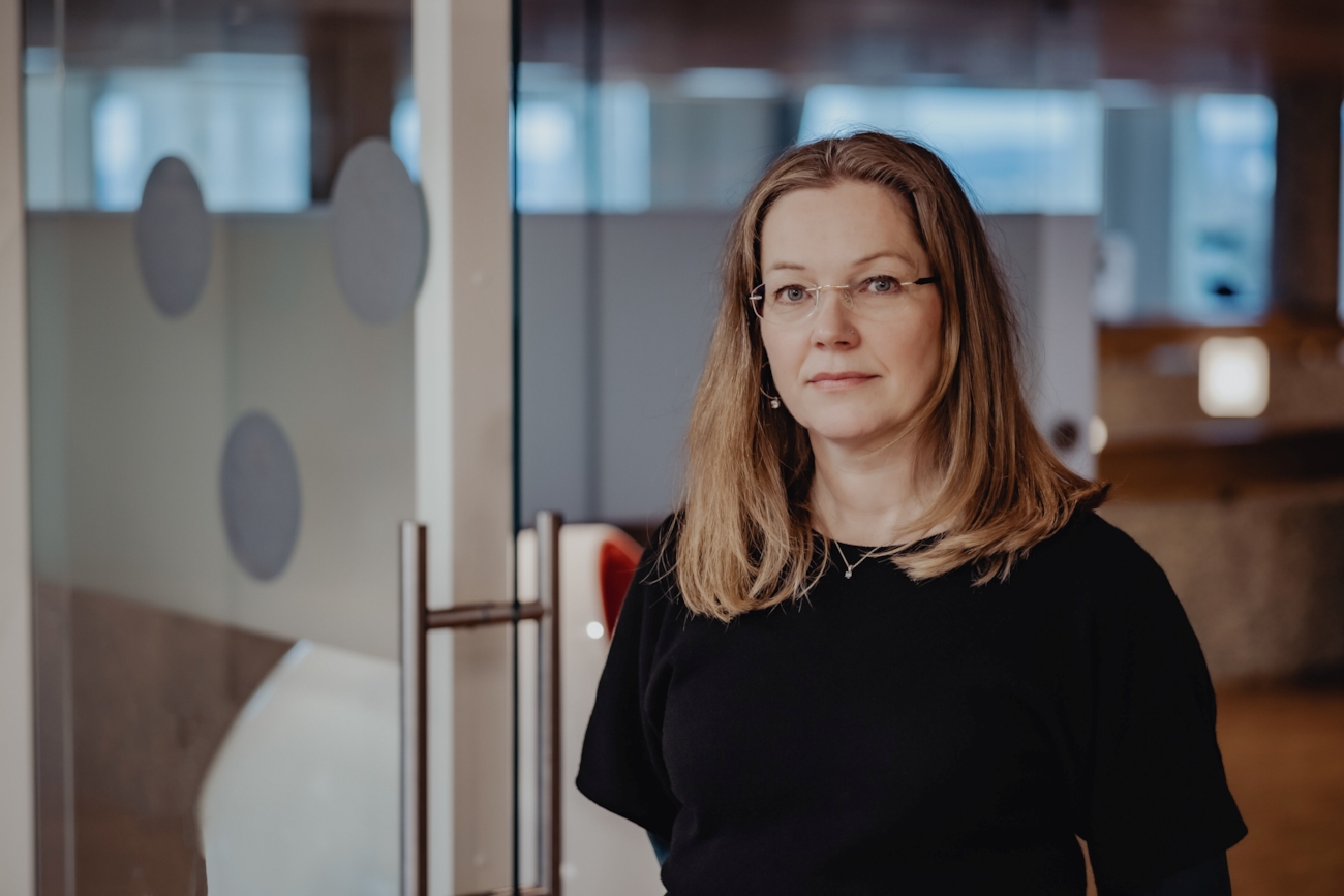 En dame ser i kamera med armene i kryss