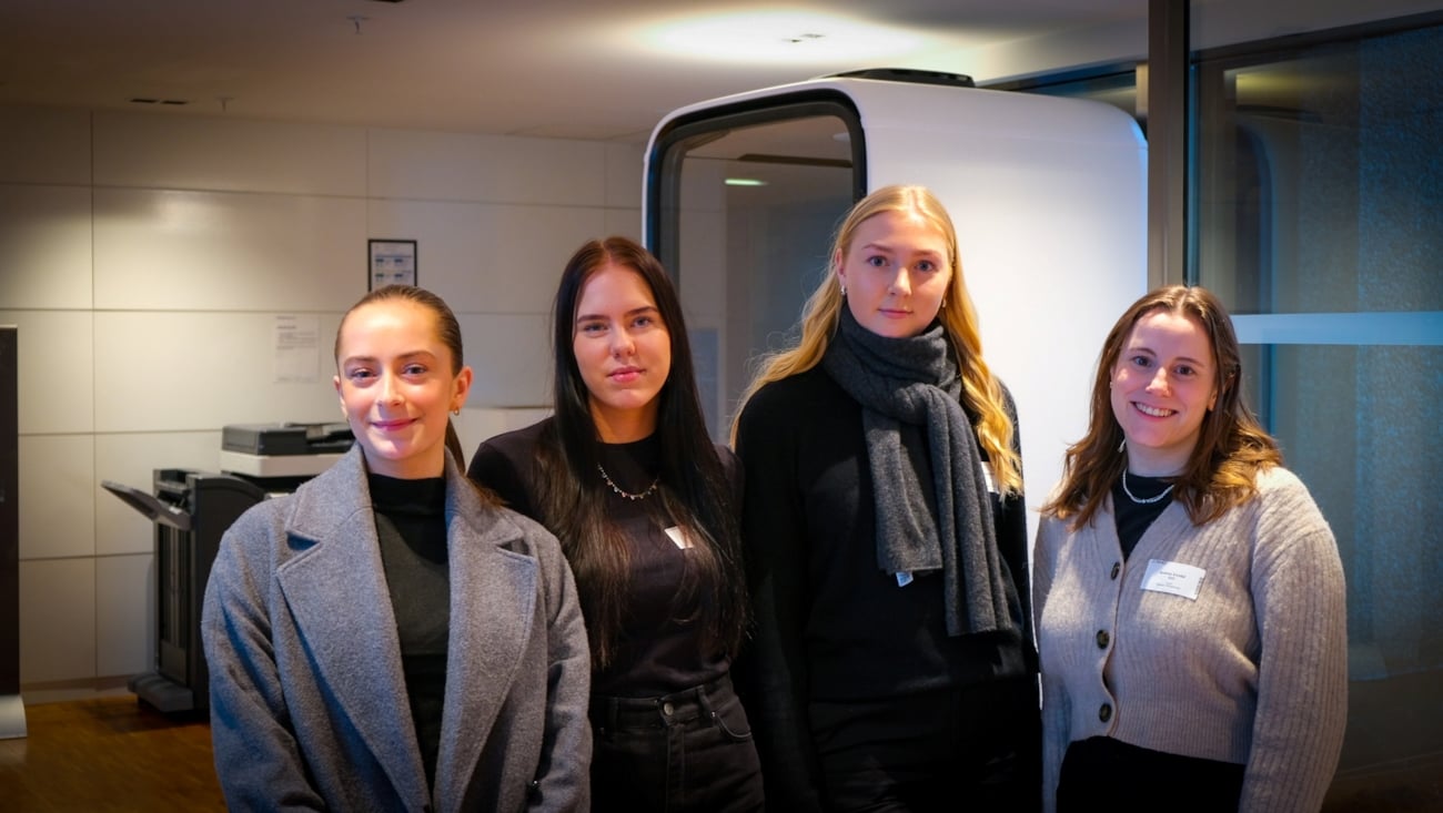 Fire damer poserer på linje og ser inn i kamera.