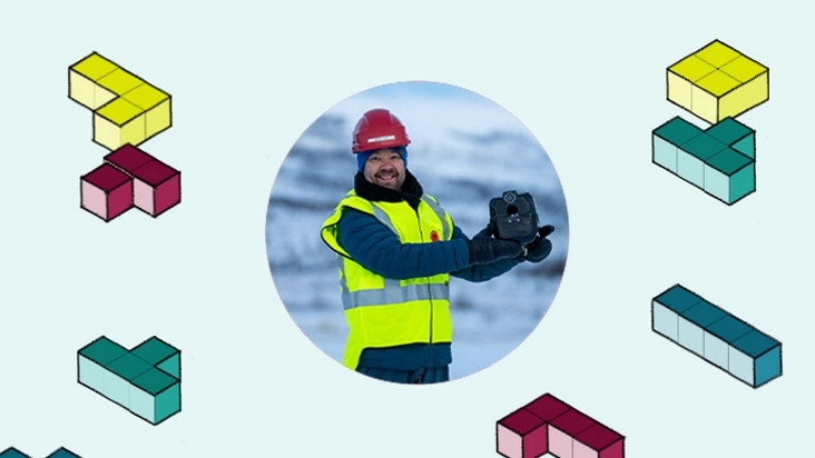 En mann med hjelm og refleksvest holder et teknisk produkt utendørs med vinterlige omgivelser. Grafiske byggeklosser dekorerer bildet.