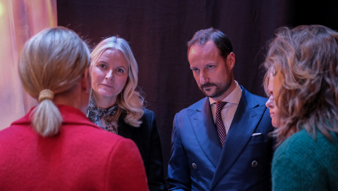 Kronprinsessen og kronprinsen er i samtale med en dame som står med ryggen til.